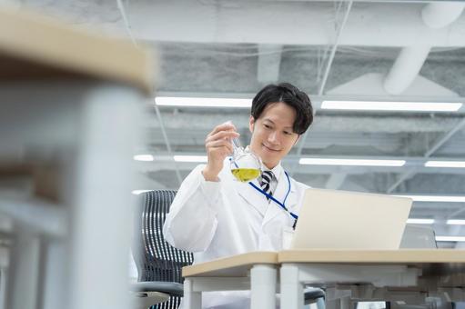 実験をする白衣の若い男性研究者 実験をする白衣の若い男性研究者 研究,実験,サイエンスの写真素材
