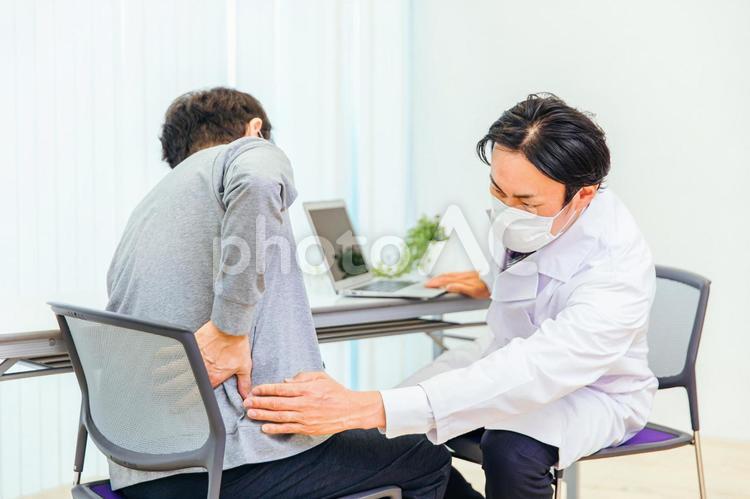 診察する男性医師（整形外科・腰） 整形外科,腰痛,ヘルニアの写真素材