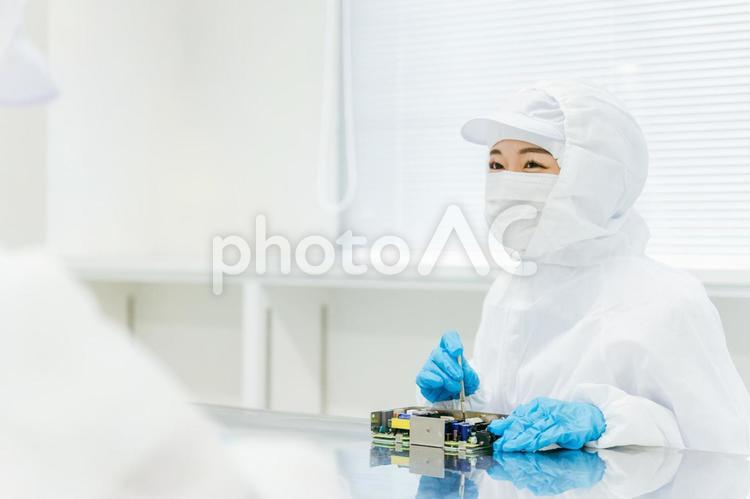 クリーンルームで精密機器を扱う女性 工場,製造業,精密機器の写真素材