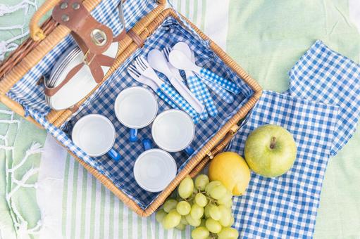 収納された食器とリンゴなどのフルーツ ピクニックバスケット,ランチ,ぶどうの写真素材