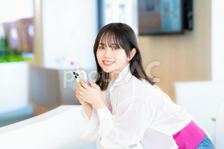 スマホを見る笑顔の女性 スマホ,若い女性,笑顔の写真素材