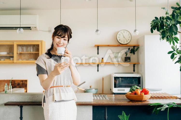 家でスマホを使う女性（アプリ） スマホ,女性,スマートフォンの写真素材