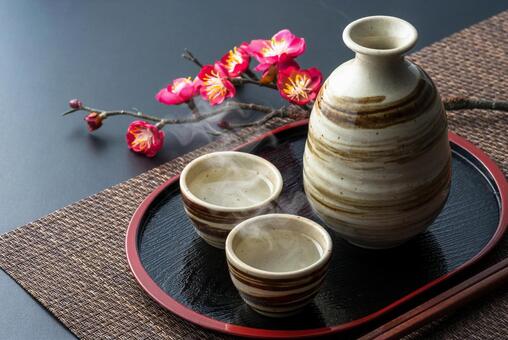 湯気の立つ日本酒と梅の枝の和風イメージ 日本酒,盃,徳利の写真素材