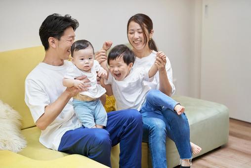 部屋のソファーでくつろぐ親子4人 部屋のソファーでくつろぐ親子4人 家族,育児,ファミリーの写真素材