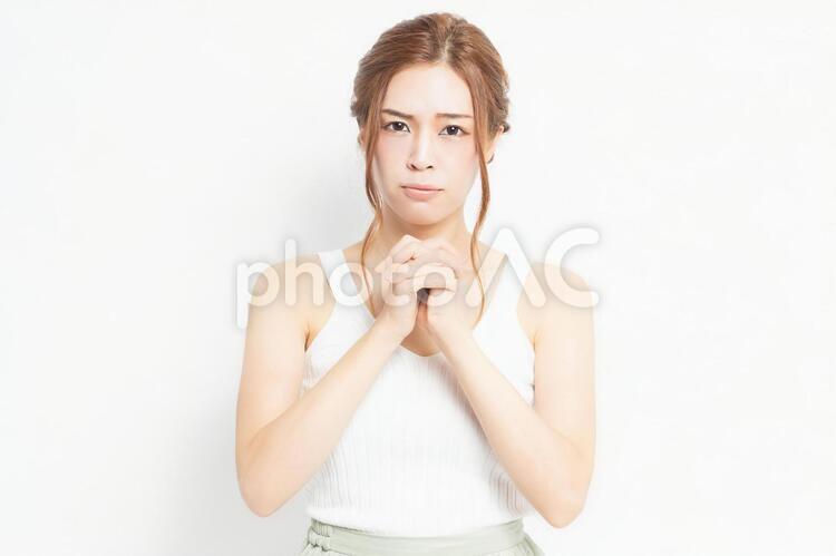 お願いのジェスチャーをする若い女性 女性,お願い,ポーズの写真素材