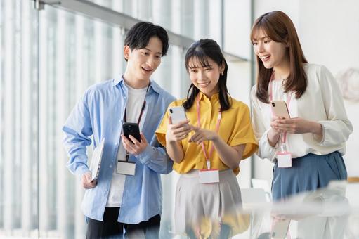 スマートフォンを使う若いビジネスパーソン スマートフォンを使う若いビジネスパーソン 若い,ビジネスパーソン,オフィスの写真素材
