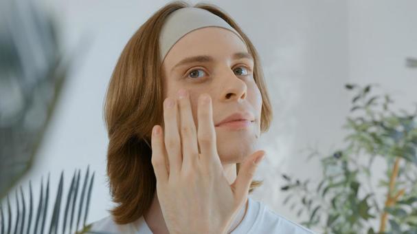 頬を触ってチェックするヘアバンドの男性 男性,外国人,欧米人の写真素材