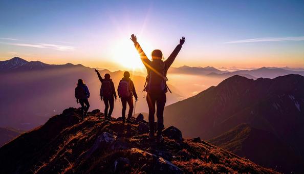 夏山で朝日に向かって手をあげる登山者 夏山で朝日に向かって手をあげる登山者の写真
