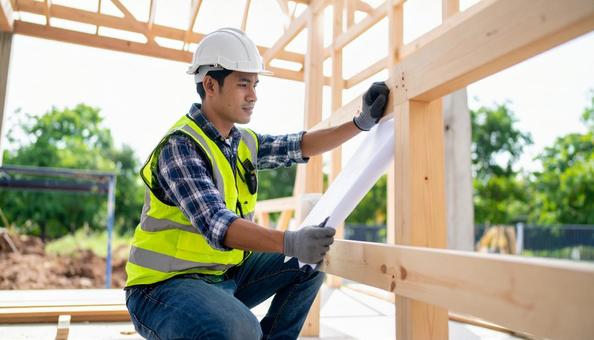 建築現場で仕事をする作業着姿の若い男性 建築現場で仕事をする作業着姿の若い男性の写真