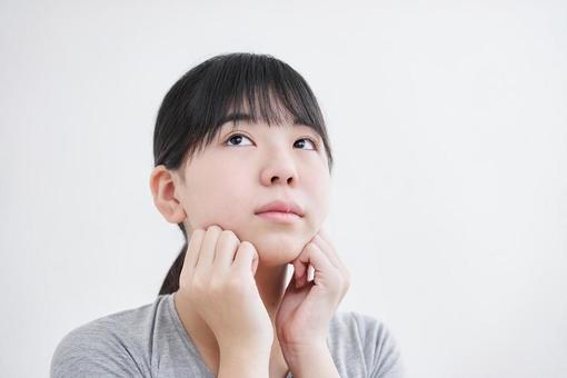 Japanese female junior high school student massaging the chin, small face, massage, girl, JPG