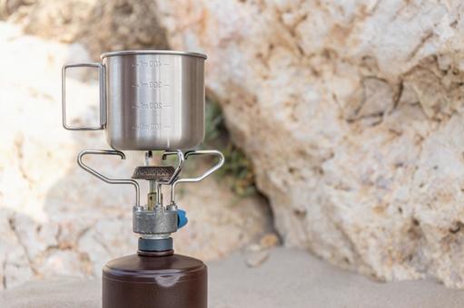 ガスバーナーとシルバーのマグの写真