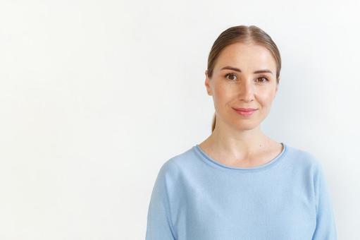 水色のカットソーを着たカメラ目線の女性（白背景） 女性,外国人,欧米人の写真素材