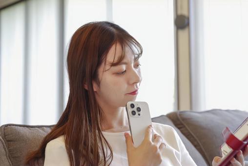 リビングで手帳の予定を確認する女性 リビングで手帳の予定を確認する女性 ノート,手帳,スケジュール帳の写真素材