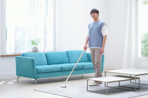 カメラ目線でラグマットを掃除中の男性 男性,カーペットクリーナー,掃除の写真素材