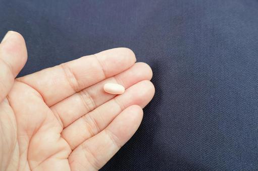 薬・サプリメント・錠剤を持つ女性の手指 薬・サプリメント・錠剤を持つ女性の手指の写真