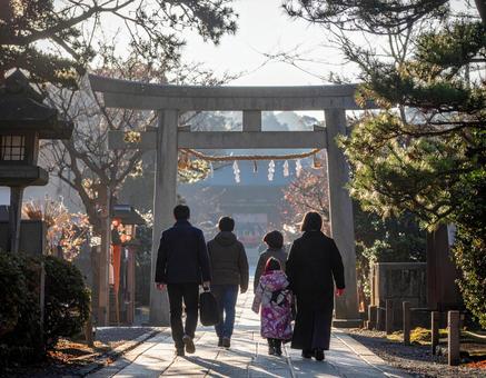 神社へ初詣に向かう家族の後ろ姿 神社へ初詣に向かう家族の後ろ姿の写真