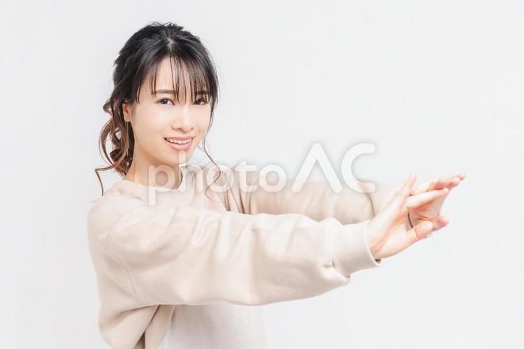 白い背景の前に立ってポーズをとる若い女性 女性,白背景,立つの写真素材