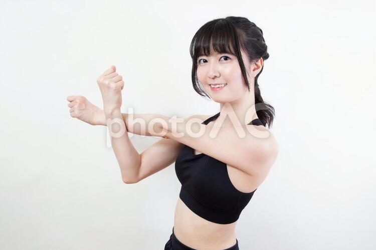 腕と肩を伸ばすストレッチをする女性 筋トレ,エクササイズ,トレーニングの写真素材
