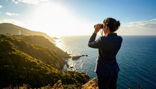 双眼鏡で海の先を見ている日本人男性 双眼鏡で海の先を見ている日本人男性の写真