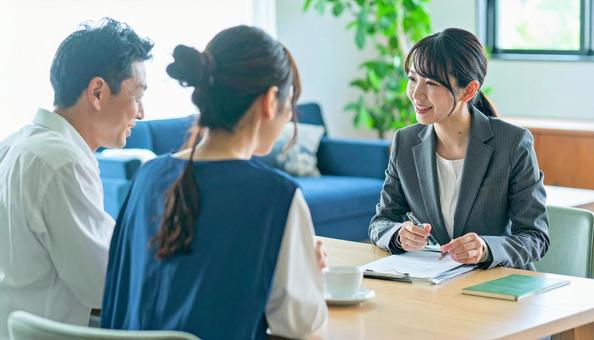 女性営業マンの説明を聞く夫婦 女性営業マンの説明を聞く夫婦の写真