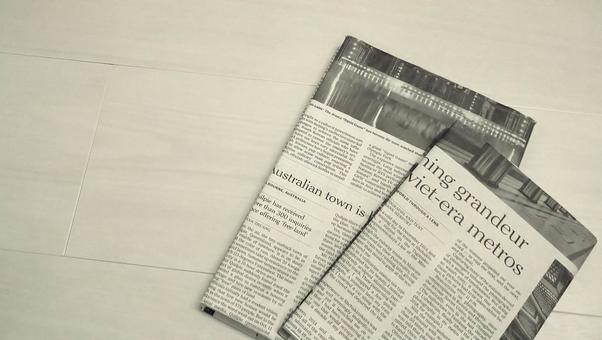 英字新聞のブックカバーをつけた書籍 英字新聞のブックカバーをつけた書籍の写真