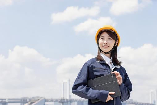 作業服を着た若い女性 作業服を着た若い女性 女性,人物,タブレットの写真素材