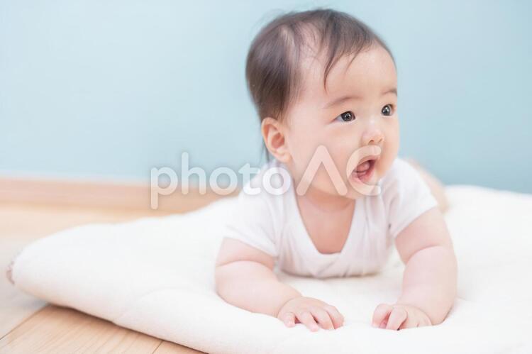 うつ伏せになった笑顔の赤ちゃん 赤ちゃん,赤ん坊,横顔の写真素材