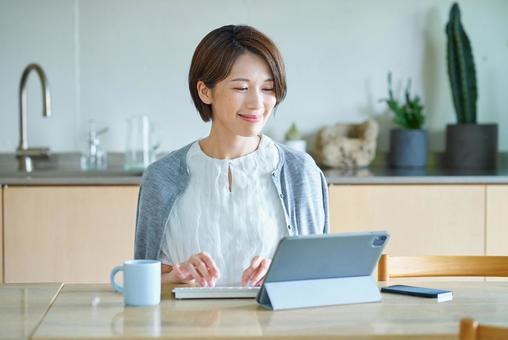 リビングルームで仕事をする女性 リビングルームで仕事をする女性 パソコン,pc,女性の写真素材