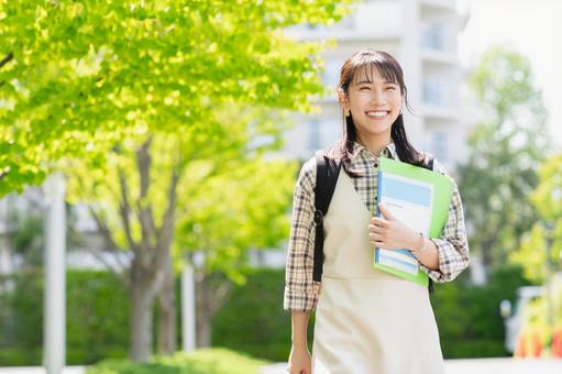 キャンパスを歩く女子大学生 キャンパスを歩く女子大学生の写真