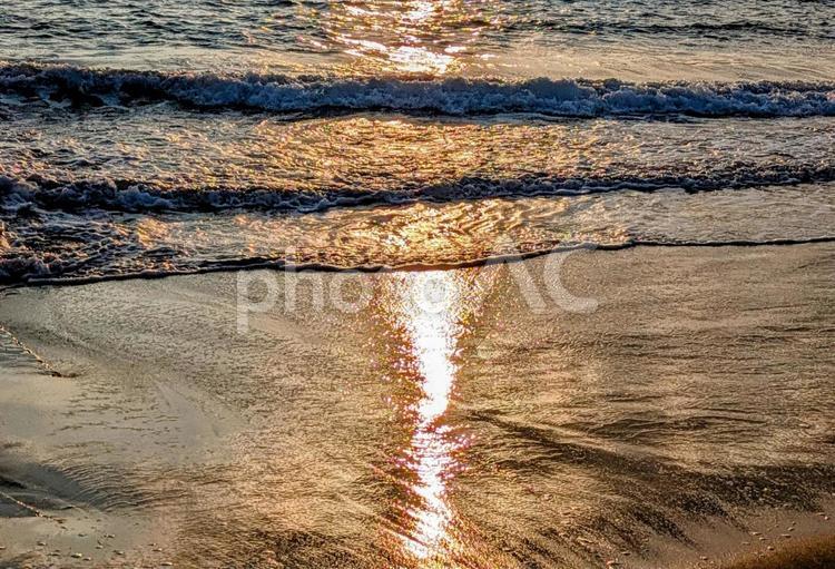 夕暮れ時の波打ち際にオレンジロード 海,夕暮れ,夕景の写真素材