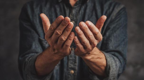 祈りを捧げる開かれた両手の写真