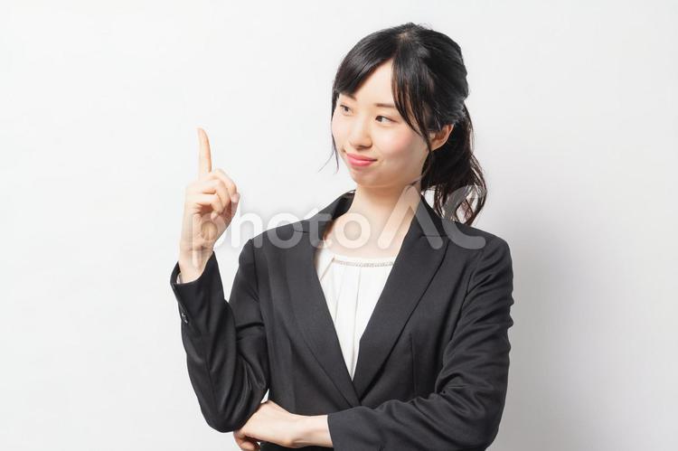 人差し指でポイントを指し示す若い女性 女性,笑顔,ビジネスの写真素材
