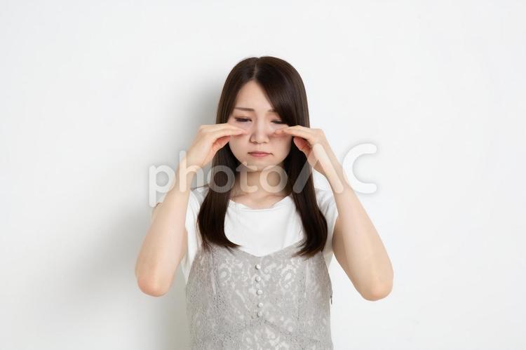 目を伏せて悲しんでいる若い女性 女,女性,女の子の写真素材