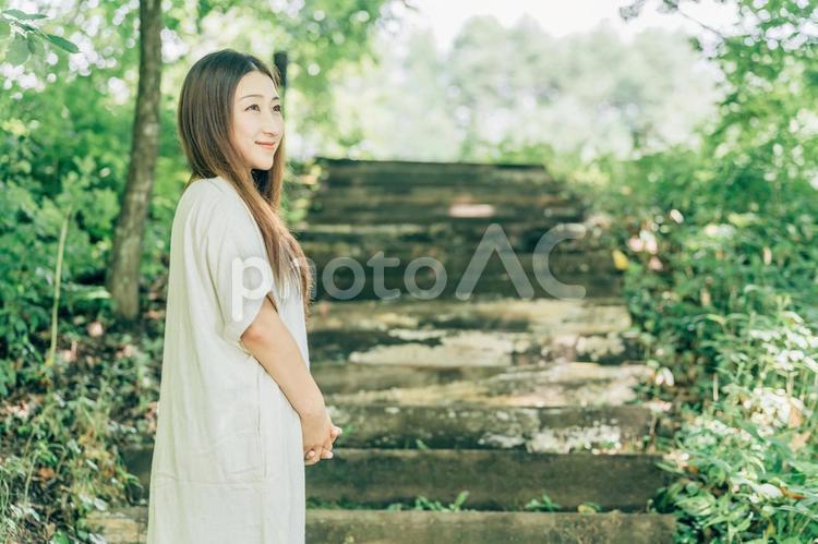 緑の中を歩く日本人女性（笑顔） 森,女性,ロングヘアーの写真素材