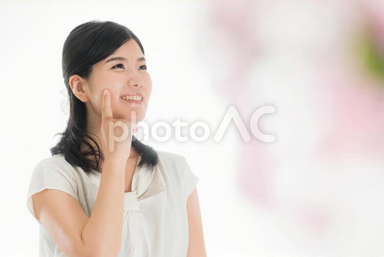 顔に人差し指をあてる笑顔の女性 春のイメージ 女性,笑顔,スキンケアの写真素材