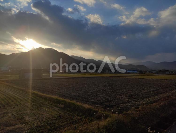 山から日が差し込む日 太陽,田舎,曇りの写真素材
