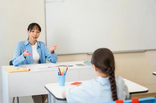 女の子にジェスチャーする先生 女性,女の子,子どもの写真素材