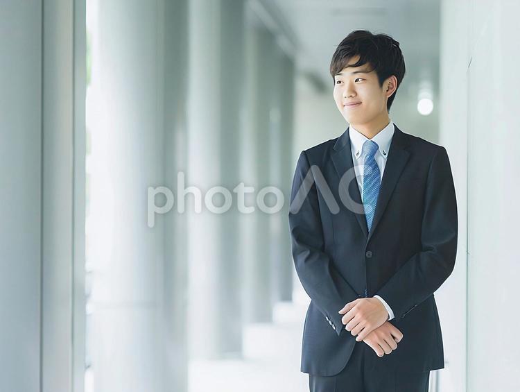 柱の並ぶ廊下に立つ若い男性社員 ビジネス,人物,スーツの写真素材