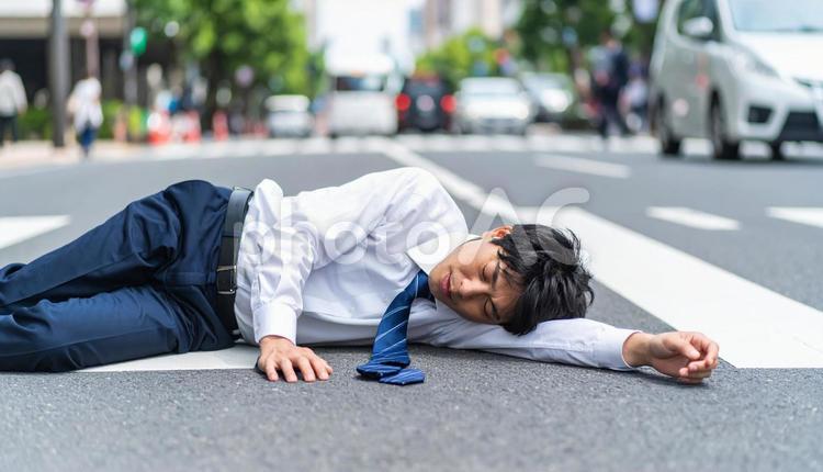 暑さでダウンし、路上に倒れる男子生徒 ダウン,倒れた,男子生徒の写真素材