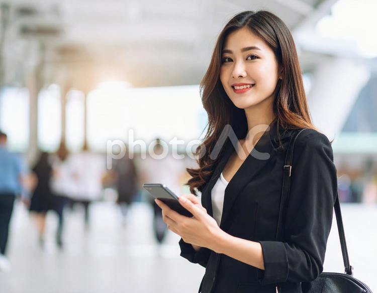 携帯電話を持つ笑顔の女性　ビジネス 女性,笑顔,スーツの写真素材