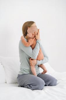 縦抱きで抱っこされる横向きの赤ちゃん 縦抱きで抱っこされる横向きの赤ちゃん 親子,母子,赤ちゃんの写真素材