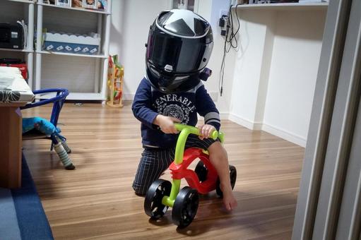 <素材>ヘルメットでバイク気分の男の子 <素材>ヘルメットでバイク気分の男の子の写真