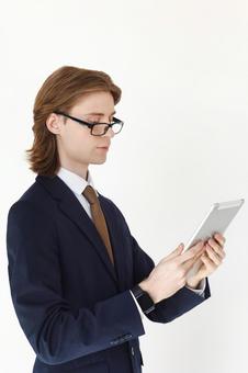 タブレットを使う横向きのスーツの男性 男性,外国人,欧米人の写真素材