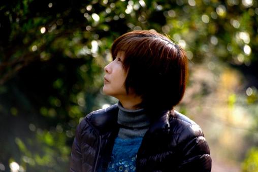 <素材>秋の森の中の公園を散策する女性 <素材>秋の森の中の公園を散策する女性の写真