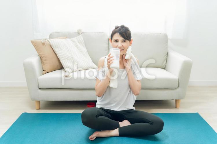 部屋でヨガをするミドル世代の女性（プロテインを飲む） プロテイン,タンパク質,ヨガの写真素材