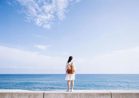 海と空と防波堤・海を眺める後ろ姿の女性 海と空と防波堤・海を眺める後ろ姿の女性の写真
