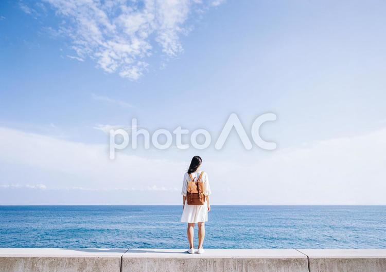 海と空と防波堤・海を眺める後ろ姿の女性 空,背景,旅の写真素材