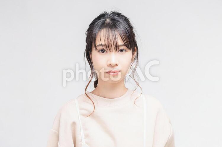 白い背景の前に立ってポーズをとる若い女性 女性,白背景,立つの写真素材