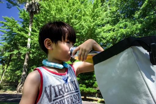 <素材>公園遊び中に水筒のお茶を飲む少年 <素材>公園遊び中に水筒のお茶を飲む少年の写真