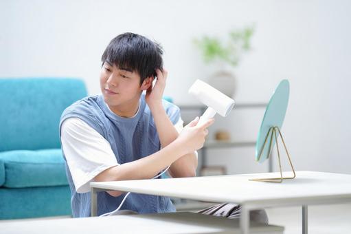 リビングでドライヤーを使う男性 男性,ドライヤー,乾かすの写真素材